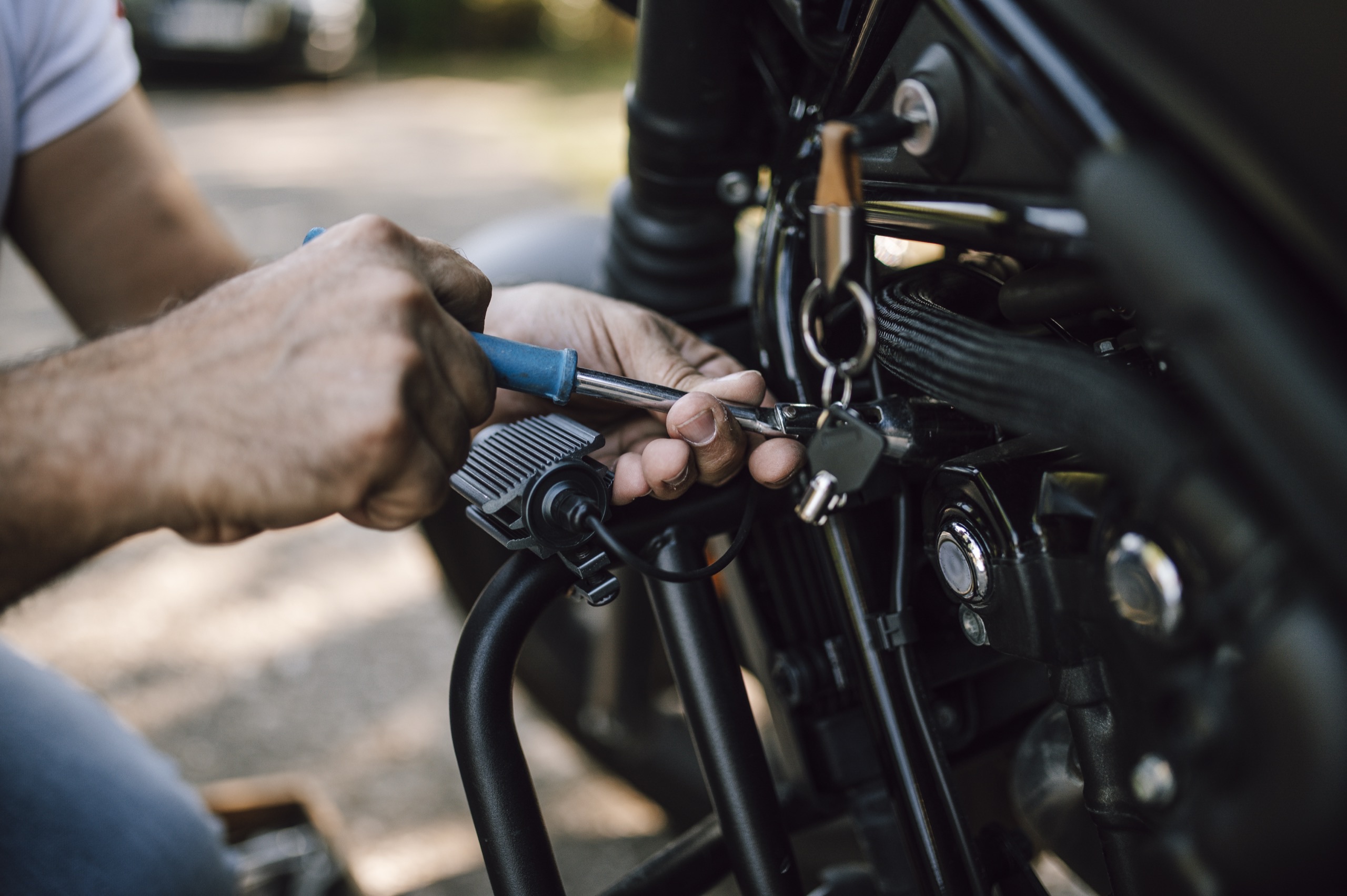 Handen met een schroevendraaier aan een zwarte motor