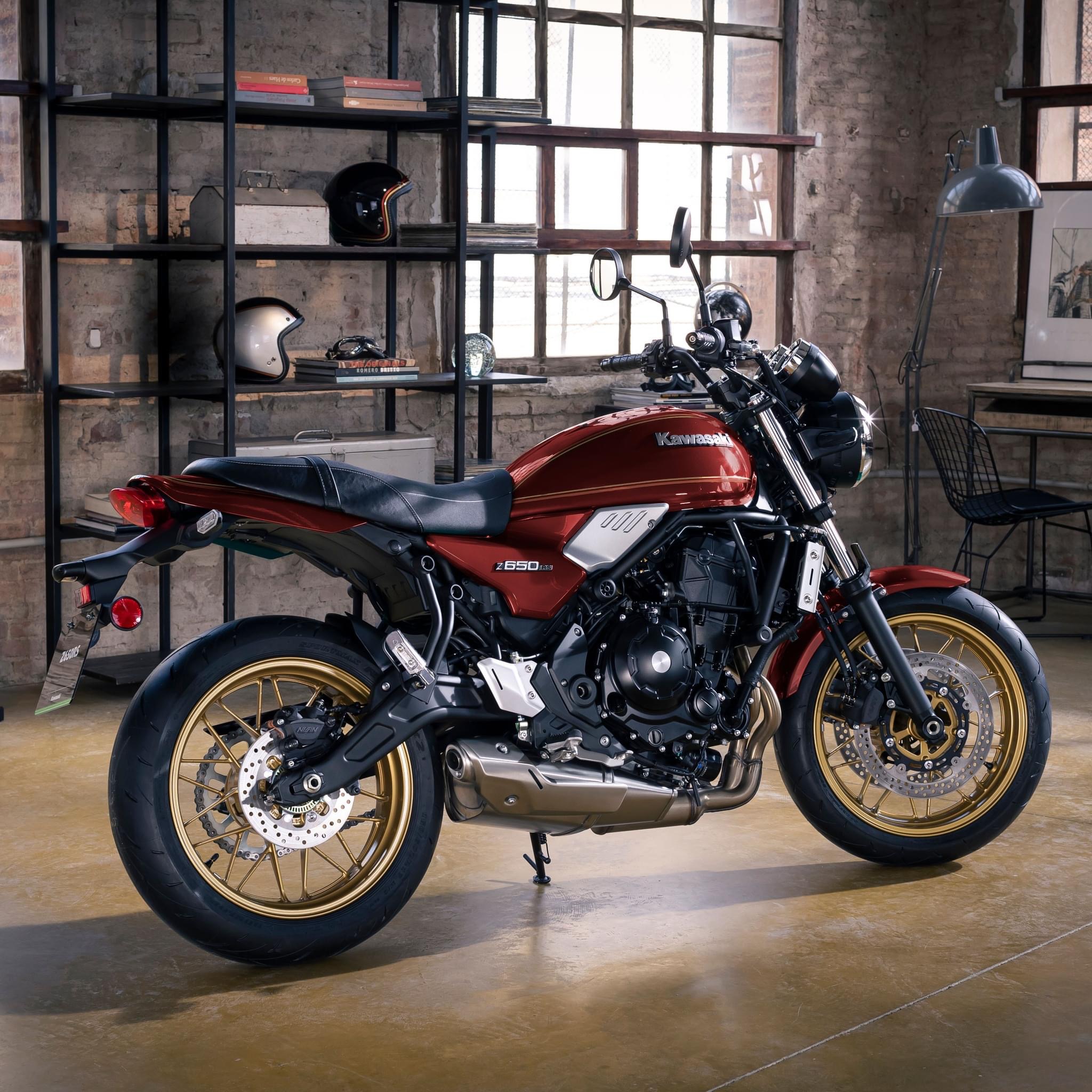 Rode Kawasaki Z650RS in een loftruimte met bakstenen muur en grote ramen