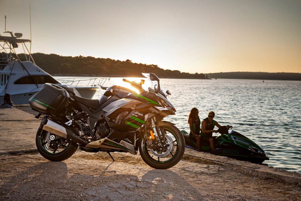 Kawasaki Ninja 1000SX met koffers bij zonsondergang aan het water
