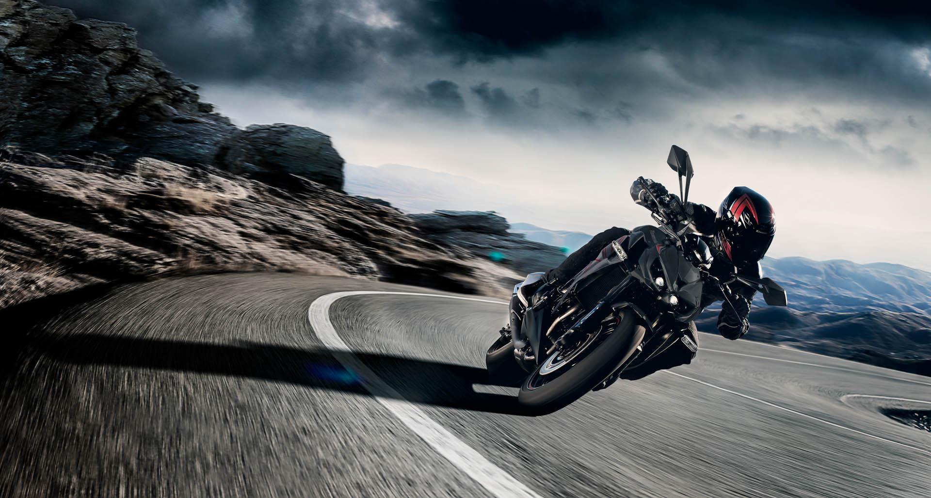 Kawasaki Z1000 in een bergbocht onder een donkere lucht